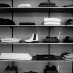 Wardrobe - Grayscale Photography of Assorted Apparels on Shelf Rack