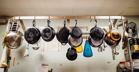 Cookware - Assorted Frying Pans Hanging on Pot Rack