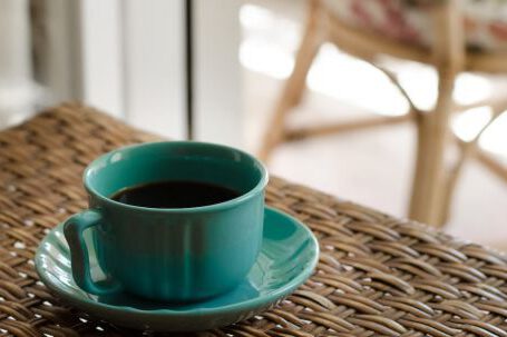 Coffee Table - Blue Coffee Cup With Saucer Filled With Coffee on Top of Wicker Table